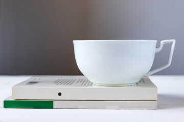 cup of tea. White cup stands on a book