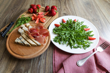 Diet summer strawberry salad with arugula on the table. 