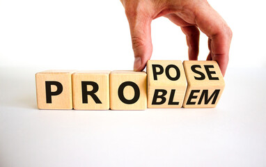 Solving a problem and propose symbol. Businessman turns wooden cubes, changes the word 'problem' to 'propose'. Beautiful white background. Business, problem and propose concept. Copy space.