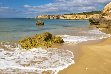 Scenic golden cliffs in the Praia do Vau beach in Portimao, Algarve, Portugal