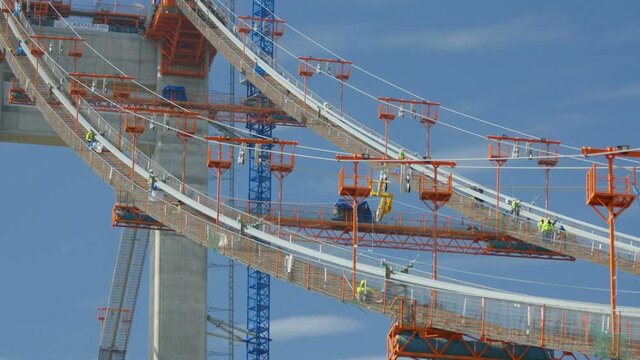 Tulcea, Romania - 20 October 2021: Steel workers lying cable stands for the suspension cable of the new bridge over the Danube, the third longest bridge in Europe