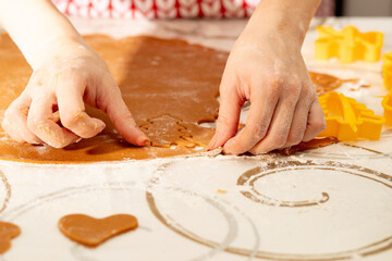 happy new year and christmas, women's hands carve shape shapes for baking gingerbread cookies