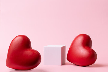 Pink podium with red heart on pastel background to show cosmetic products. Minimal romantic...