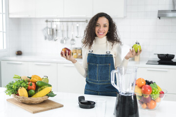 Beautiful woman making fruits smoothies with a blender. Healthy eating lifestyle concept.