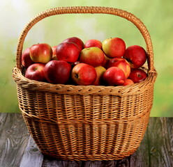 Red apples in wicker basket on the table. Fresh ripe apples in basket