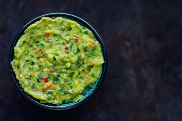 Bowl of guacamole on a dark background. Traditional mexican dip sauce guacamole. Traditional...