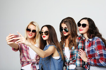 happy teenage girls with smartphone taking selfie