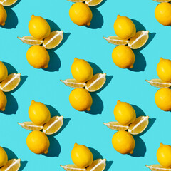 Trendy sunlight summer pattern made with yellow lemon slice on bright light blue background. Minimal summer concept. Flat lay.