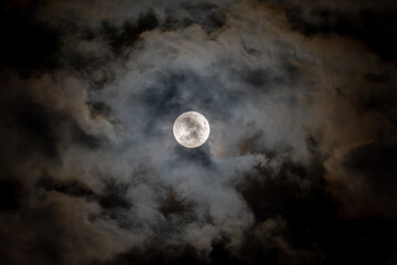 Naklejka na ściany i meble Full moon on the background of clouds in the night scenery