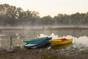 Boats on the river bank in the morning mist