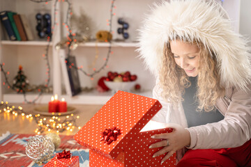 Obraz na płótnie Canvas Happy young girl opening a Christmas present box