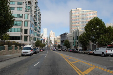 Fototapeta na wymiar Street of San Francisco. Road on a slope with a view of skyscrapers, cars and a bus 