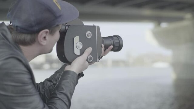 A man shoots a movie with an old vintage camera