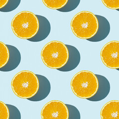 Seamless fruit pattern of fresh orange slices on blue background. Top view. Copy Space. Pop art design, creative summer concept. Half of citrus in minimal flat lay style.