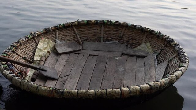 An empty Coracle parked in Cauvery river in Srirangapatna, Karnataka, India. A coracle is a small, bowl shaped, lightweight boat made of bamboo
