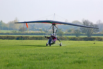 Fototapeta na wymiar Ultralight airplane taxiing on a farm strip 