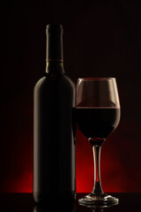a red wine bottle with the glass half full