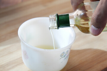 detail shot of Pouring vegetable oil in a cup 