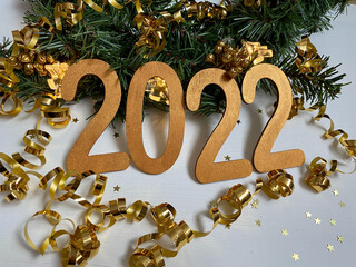 Happy New Year 2022.  2022 symbol wooden numerals of gold color on a white background.  New Year's composition with elements of New Year's decor.  Top view, flat lay.