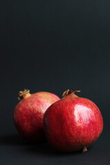 red fresh pomegranate fruit on black background