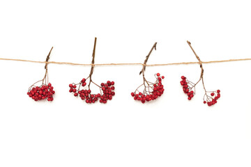 Garland made of twine and red rowan isolated on white background. Simple design. Rustic decor. Farmhouse concept. Horizontal photography.