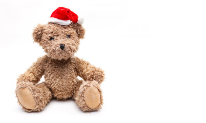 Kleiner Teddybär mit Weihnachtsmütze auf weissem Hintergrund