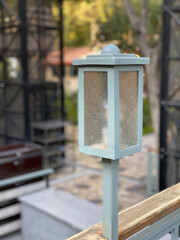 A light blue street lamp on the open veranda.