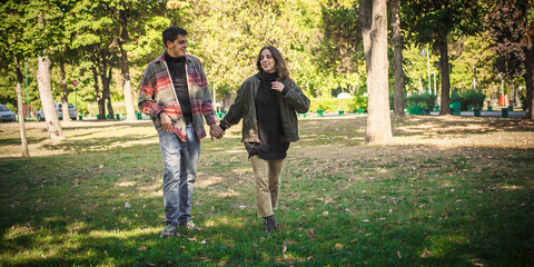 Cheerful and romantic couple in love, walk together in nature