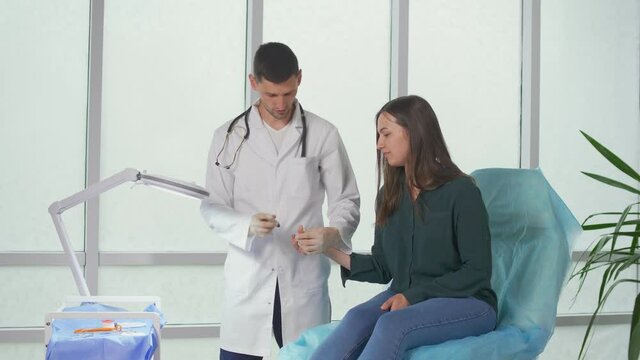 The Doctor Does a Blood Sugar Test and Checks The Blood Sugar Level of A Diabetic Patient with a Lancet Glucometer at the Tip of His Finger. Analyzes and Consultations in the Clinic.