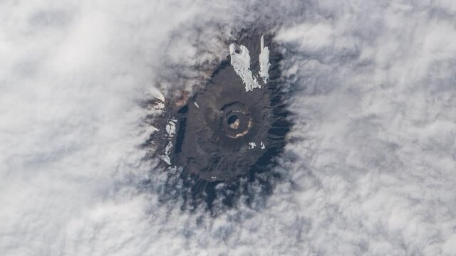 Mountain peak from clouds view from sky, aerial satellite scenic landscape of Kilimanjaro mount in Tanzania, Africa. Animation based on Nasa images