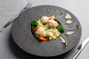 Plate of meatballs with white sauce and penne pasta, baby carrot and broccoli. Grey stone background. Close up. Top view.