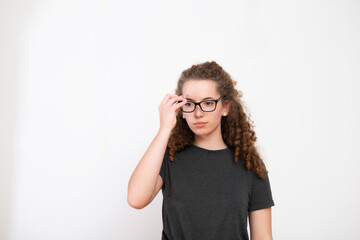 Casual young female with brown curly hairstyle and eyeglasses over white background