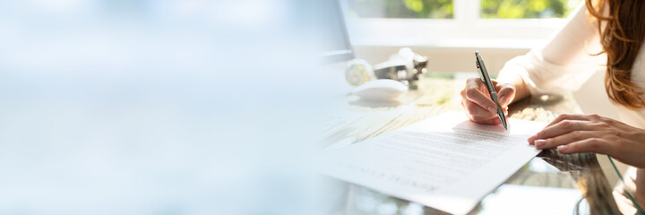 Businesswoman's Hand Signing Contract With Pen