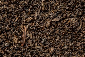 Heap of dry tea leaves. Dried black tea. Textured background of dried leaves of aromatic black tea with cinnamon