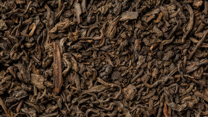Heap of dry tea leaves. Dried black tea. Textured background of dried leaves of aromatic black tea with cinnamon