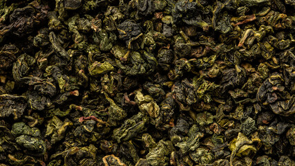 Heap of dry tea leaves. Dried green tea. Textured background of dried leaves of aromatic tea.