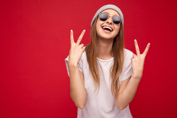 Photo of young positive happy smiling beautiful hipster woman with sincere emotions wearing stylish clothes isolated over background with copy space