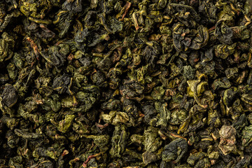 Heap of dry tea leaves. Dried green tea. Textured background of dried leaves of aromatic tea.