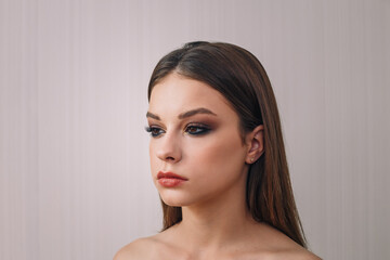 Fototapeta premium Beautiful teenage girl model getting professional make-up. Beauty portrait of female teenager in process of visage. Cosmetics, beauty standards, skin care concept. Close up shot.