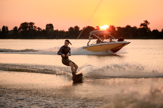 Active Wakeboarding Training. Man Holds Cable And Rolls On The Wave.