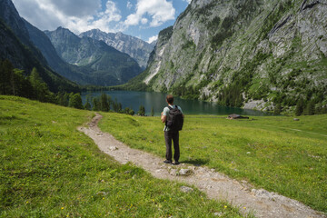 Man with backpack on hiking trail enjoying Hinterer Gosausee, Salzkammergut. Austria
