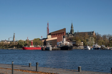 Fototapeta premium View over museums and landmarks on the island Djurgården from the island Skeppsholmen in Stockholm a color full autumn day