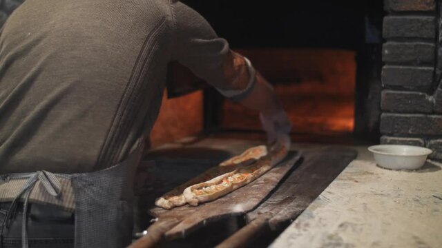 shot of cooking turkish bread cooked in wood fired oven. traditional recipe, food and drink close up footage. Turkish pide bread, tourism Turkey