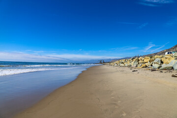 a gorgeous shot of the beach with smooth silky sand, birds walking on the sand, waves rolling in...