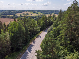 Fototapeta na wymiar Areal drone photography of highway near forest and agriculture fields.