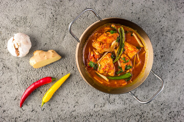 Traditional Pakistani and North Indian chicken karahi garnished with garlic, ginger and chillies
