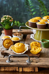Pumpkin muffins with white chocolate and walnuts. Side view, wooden and green background.