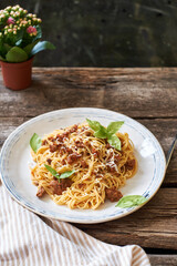 Spaghetti with bolognese sauce and basil. Side view, horizontally, wood background.
