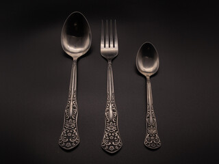 Spoon, fork on a dark background