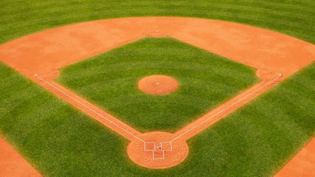 Huge green baseball field. Sport stadium with grass and orange field with sand.